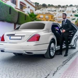 Taxi Algeciras - A high-end, VIP taxi service scene in Algeciras, Spain, featuring a luxurious white limousine-style car. The image depicts an elegant setting with the